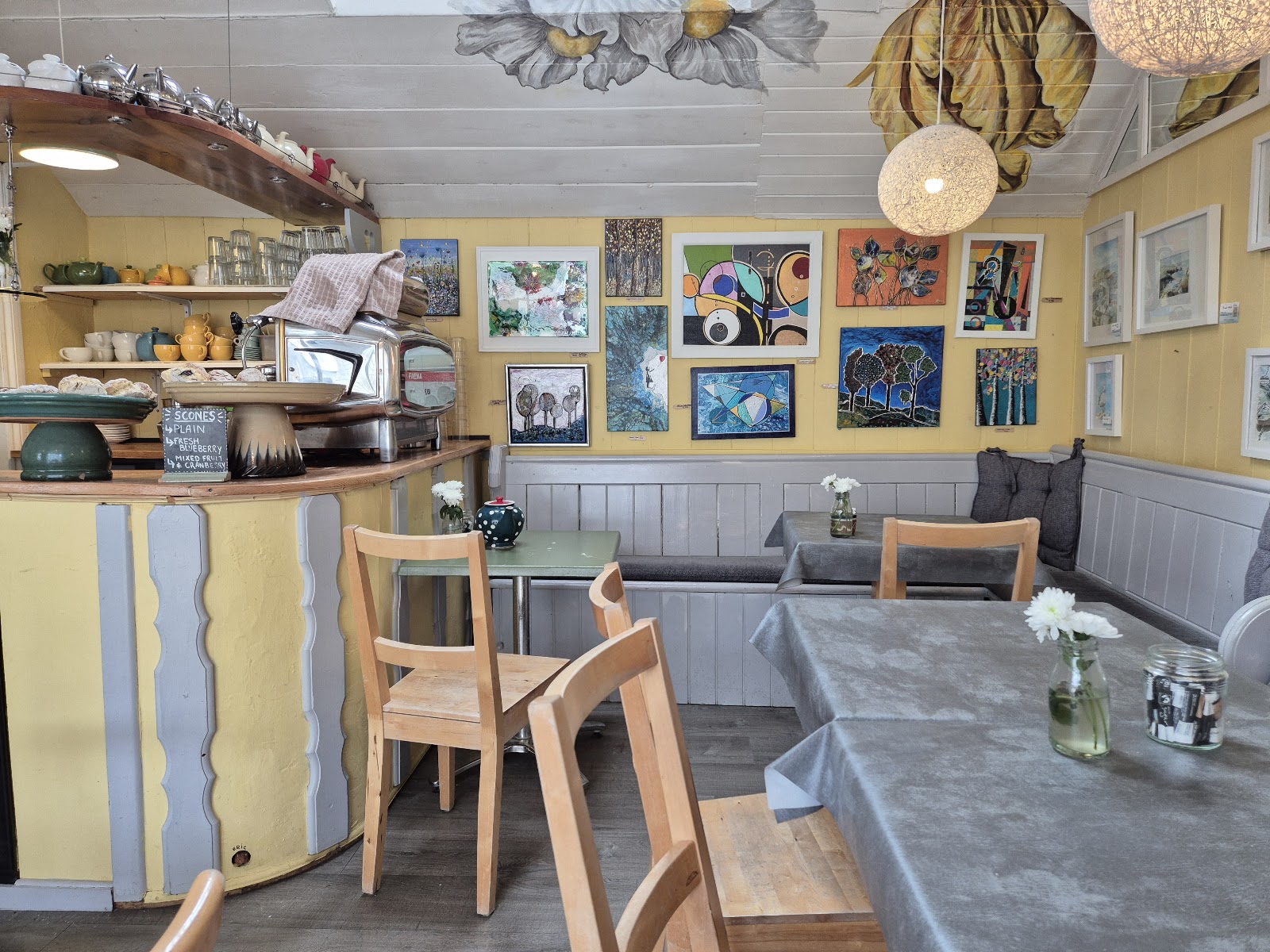 Inside the cafe — sunny yellow walls hung with local artwork